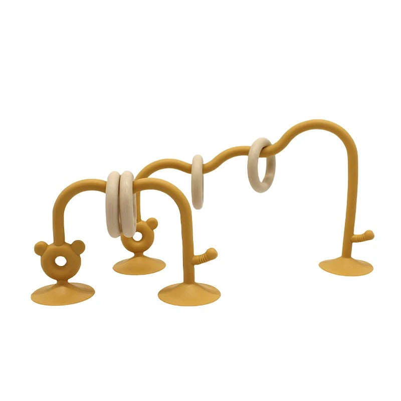 Yellow silicone bead maze toy for babies with suction base for feeding chair.