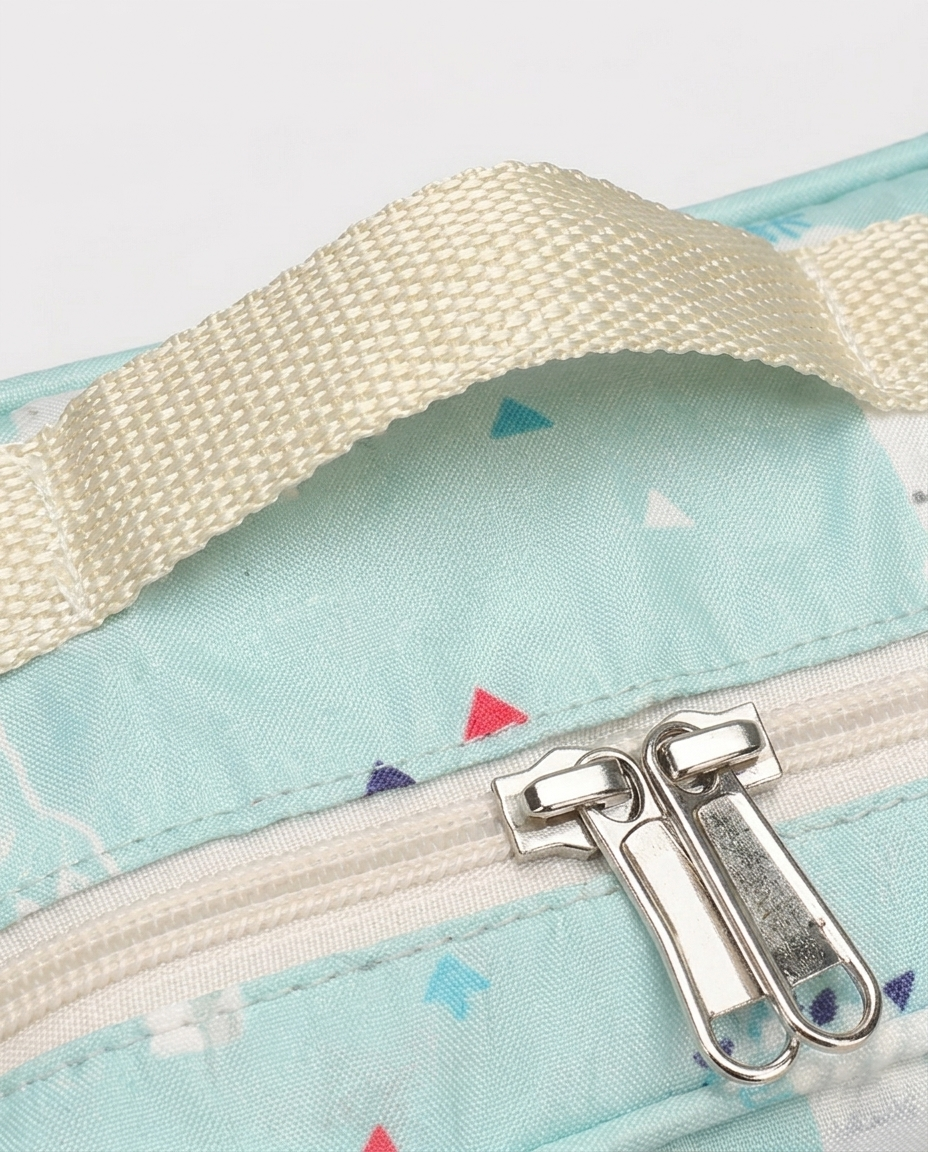 Close-up of nappy bag double zipper pulls and cotton canvas handle detail on mint green alpaca print