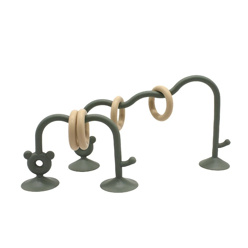 Green silicone bead maze toy for babies with suction base and smooth curved design.