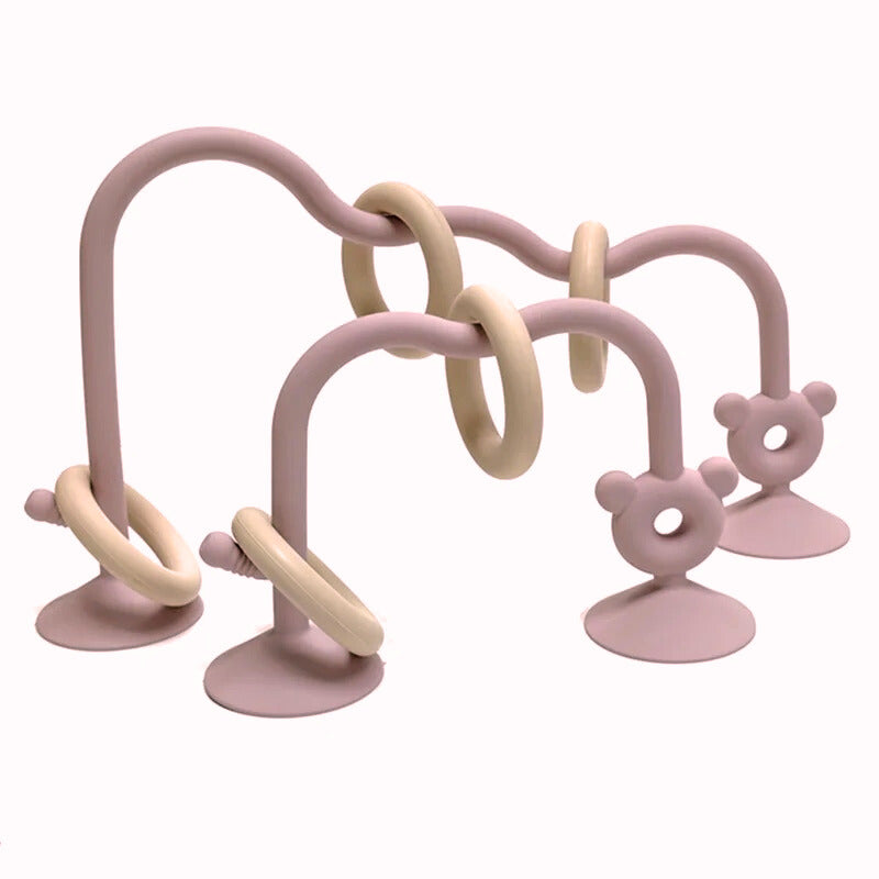 Light pink silicone bead maze toy for babies with suction base and smooth curved design.