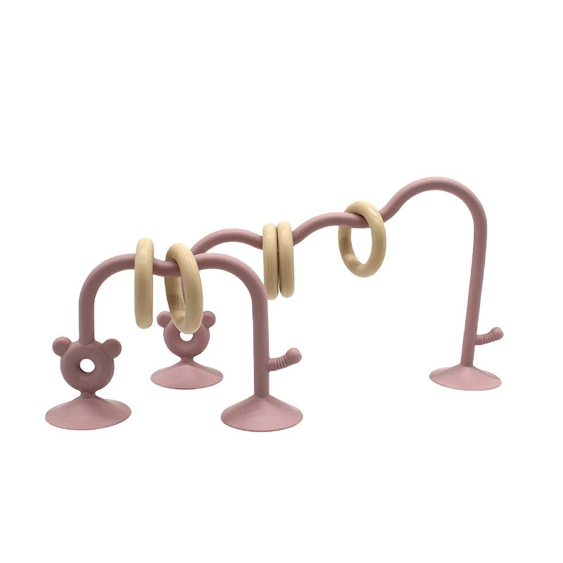 Silicone bead maze toy in light pink designed for baby sensory play on feeding chair.