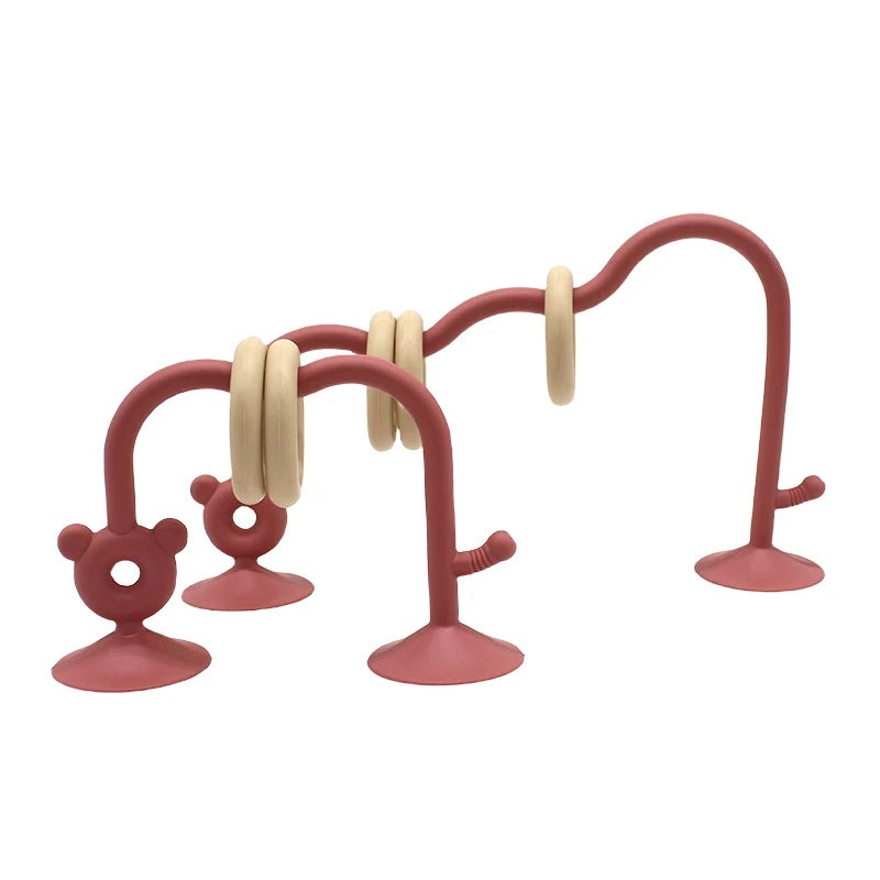 Silicone bead maze toy in reddish pink for fine motor skill development.