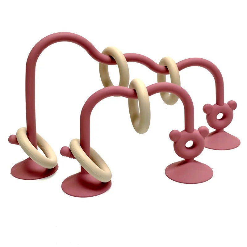 Reddish pink silicone bead maze toy showing curved structure and movable rings.