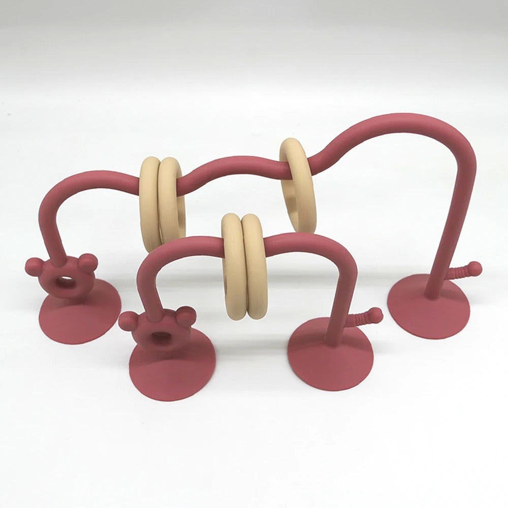 Silicone baby bead maze toy in reddish pink designed for high chair activity.