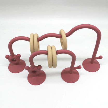 Silicone baby bead maze toy in reddish pink designed for high chair activity.