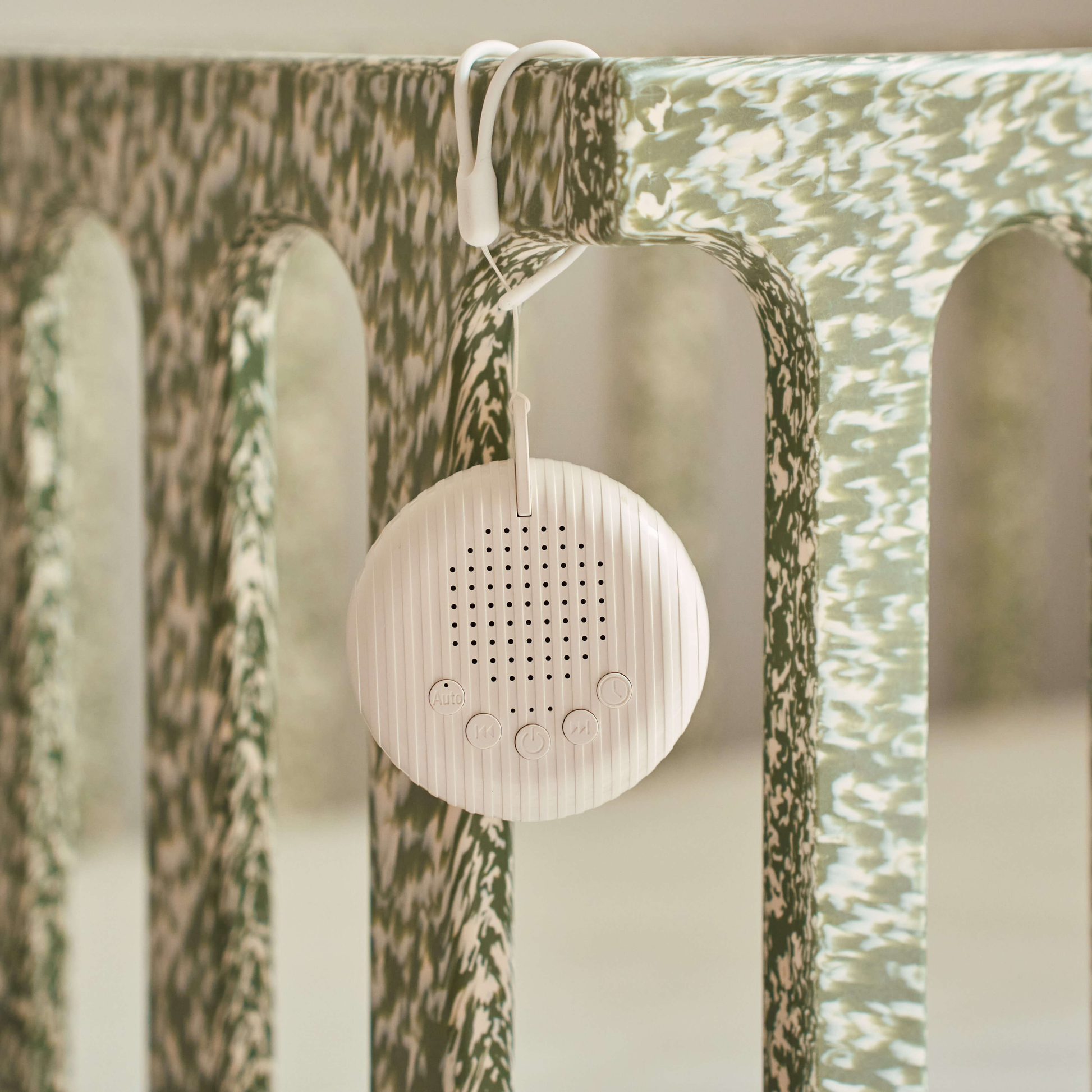 Portable baby white noise machine hanging on crib rail for soothing sleep