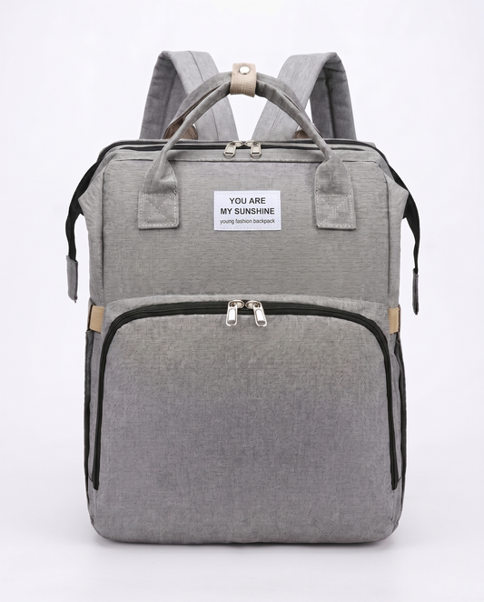 Grey foldable baby diaper backpack with carry handles, large front pocket and beige zip detail