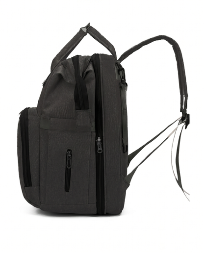 Black baby diaper bag backpack side view showing multiple zip pockets and padded shoulder strap