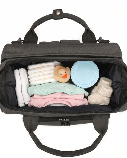 Black baby diaper bag backpack open top view packed with nappies, baby clothes and toys