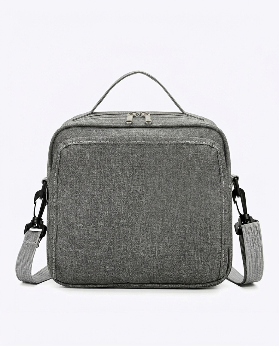 Compact grey nappy bag with dual zip closure and adjustable shoulder strap on white background