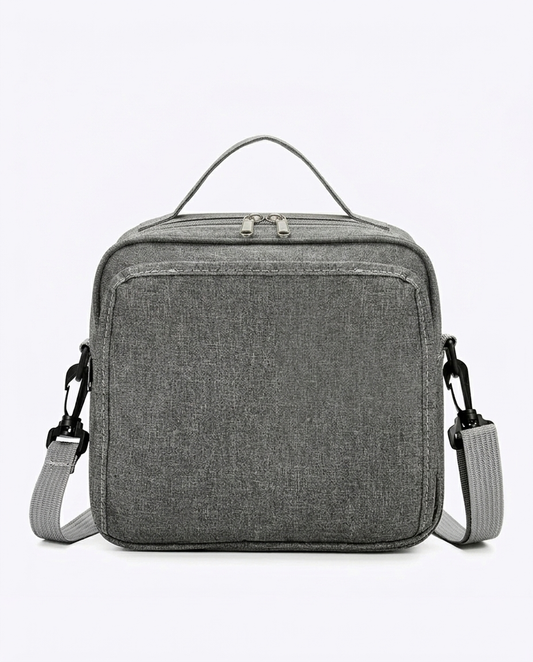 Compact grey nappy bag with dual zip closure and adjustable shoulder strap on white background
