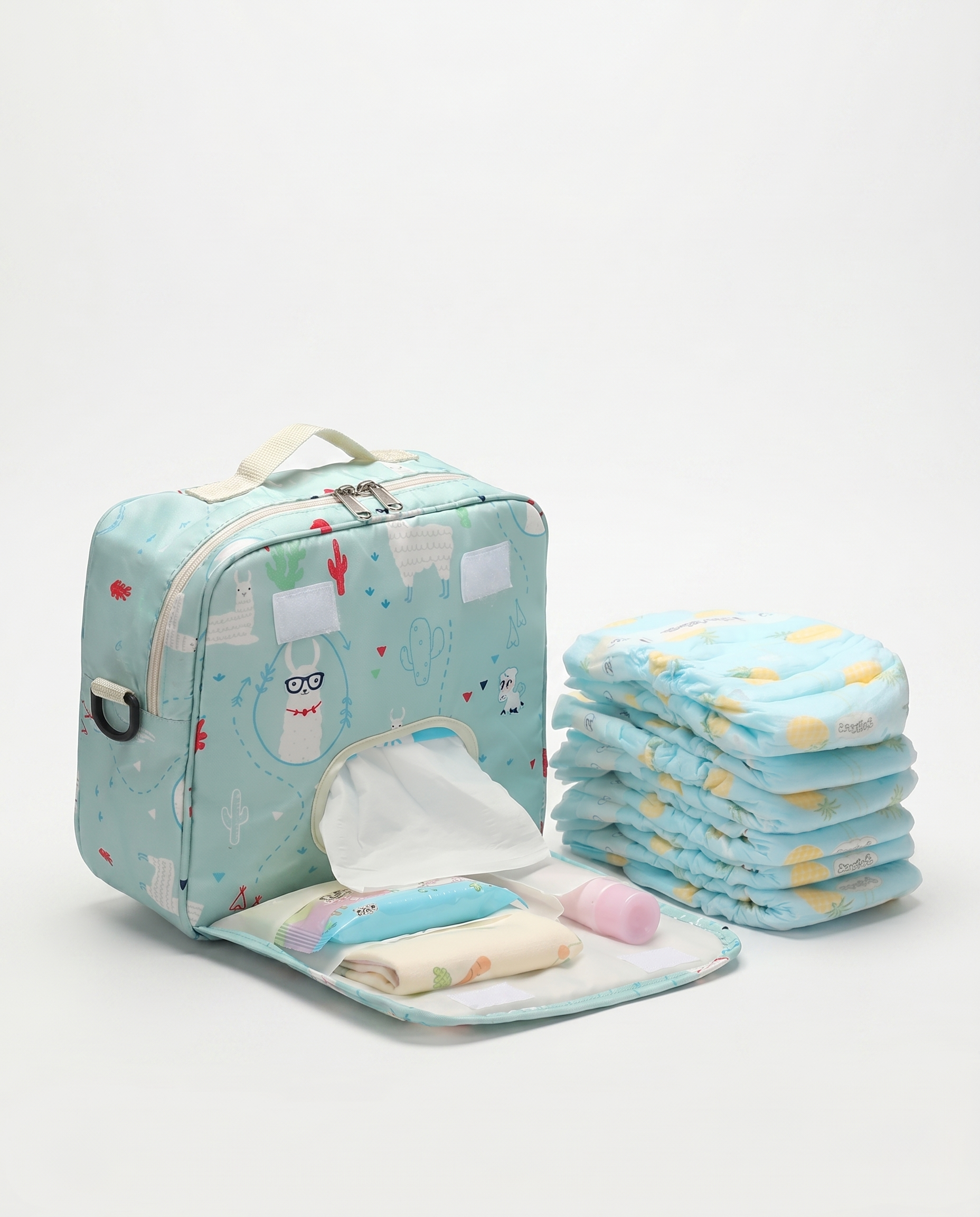 Nappy bag with open changing mat showing capacity next to a stack of folded nappies