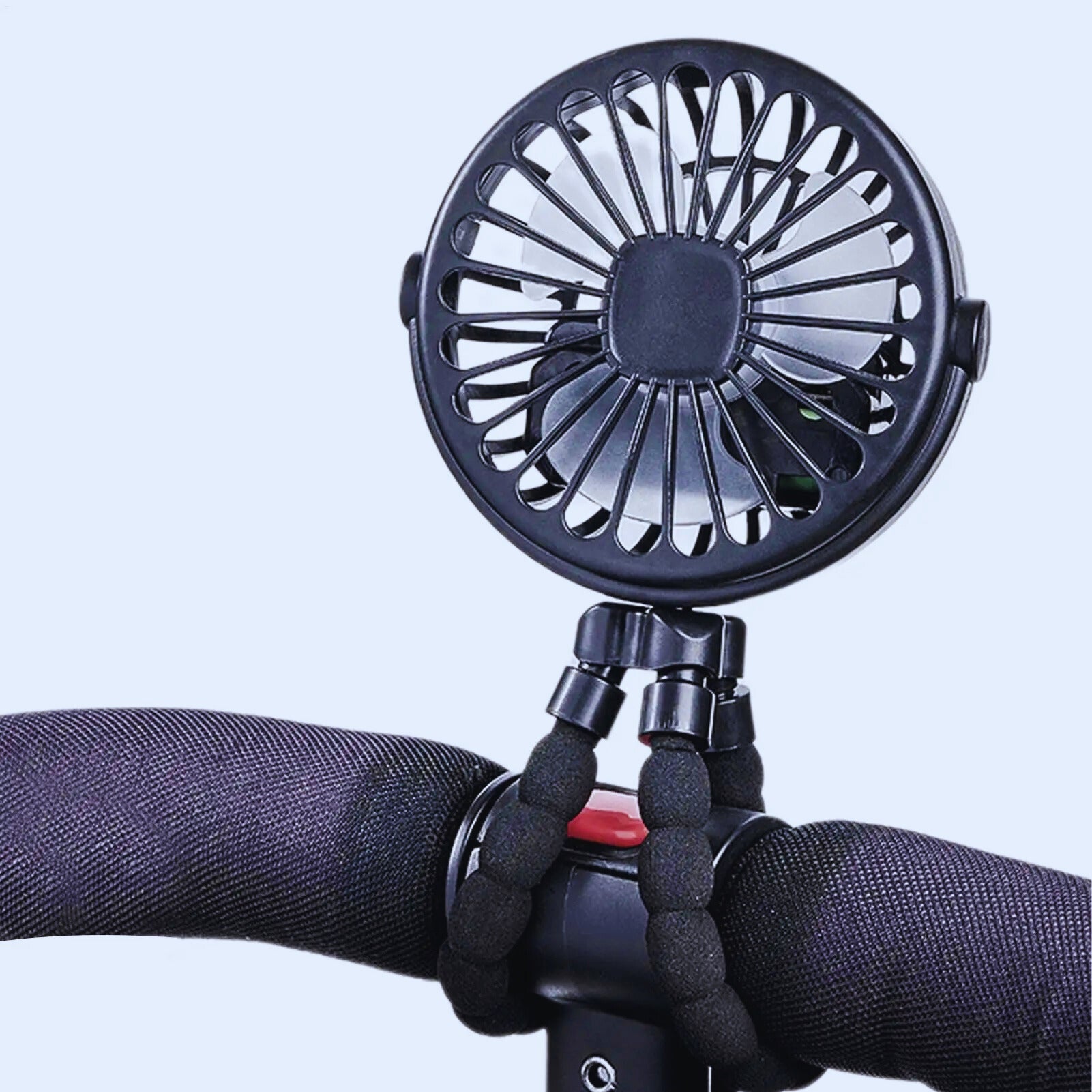 Black portable stroller fan with flexible legs wrapped around stroller handle.